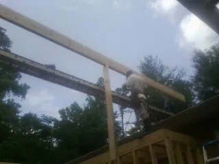 Carpenter setting a ridge beam over a new addition frame — Ice Dam Removal by Roofing Brothers in Berwyn
