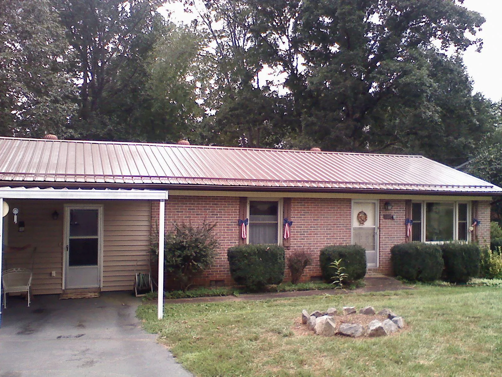 Bronze metal roof and carport on a brick ranch home — Roof Repair work by our crew in Berwyn